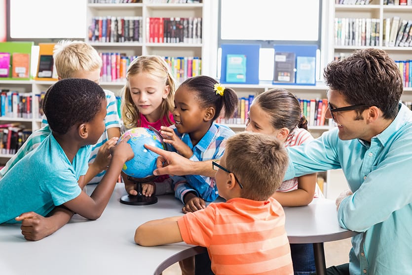 Lehrer und Kinder, die in der Kita über den Globus diskutieren, Shutterstock, wavebreakmedia